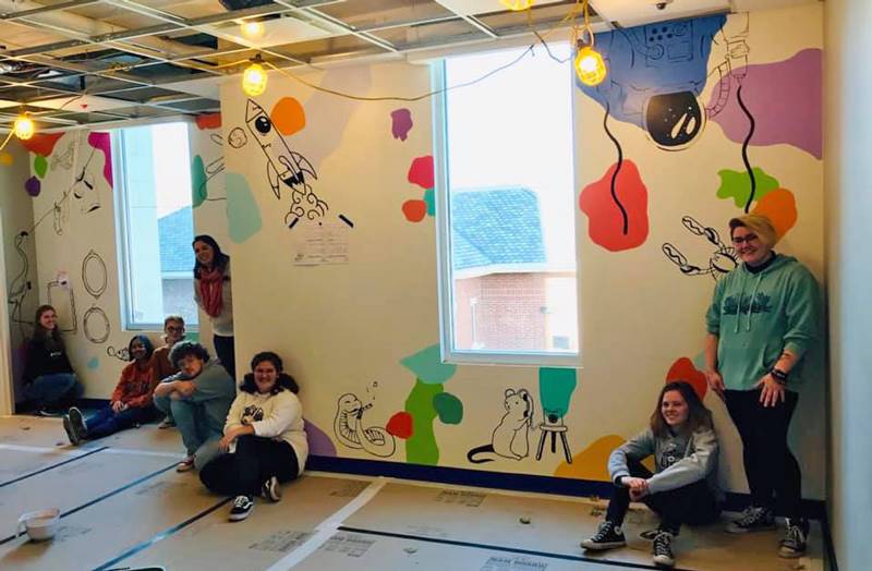 Washington High School faculty and students hand-paint their mural in Dax's Playroom at the Peoria Ronald McDonald House® in Peoria, Illinois.
