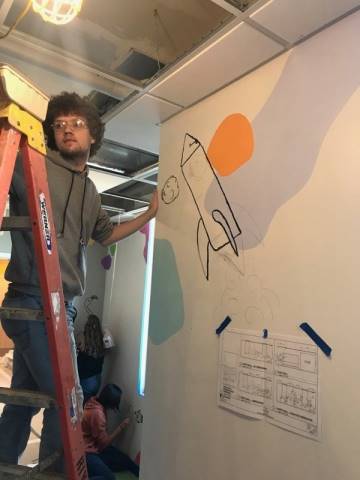 Washington High School faculty and students hand-paint their mural in Dax's Playroom at the Peoria Ronald McDonald House® in Peoria, Illinois.